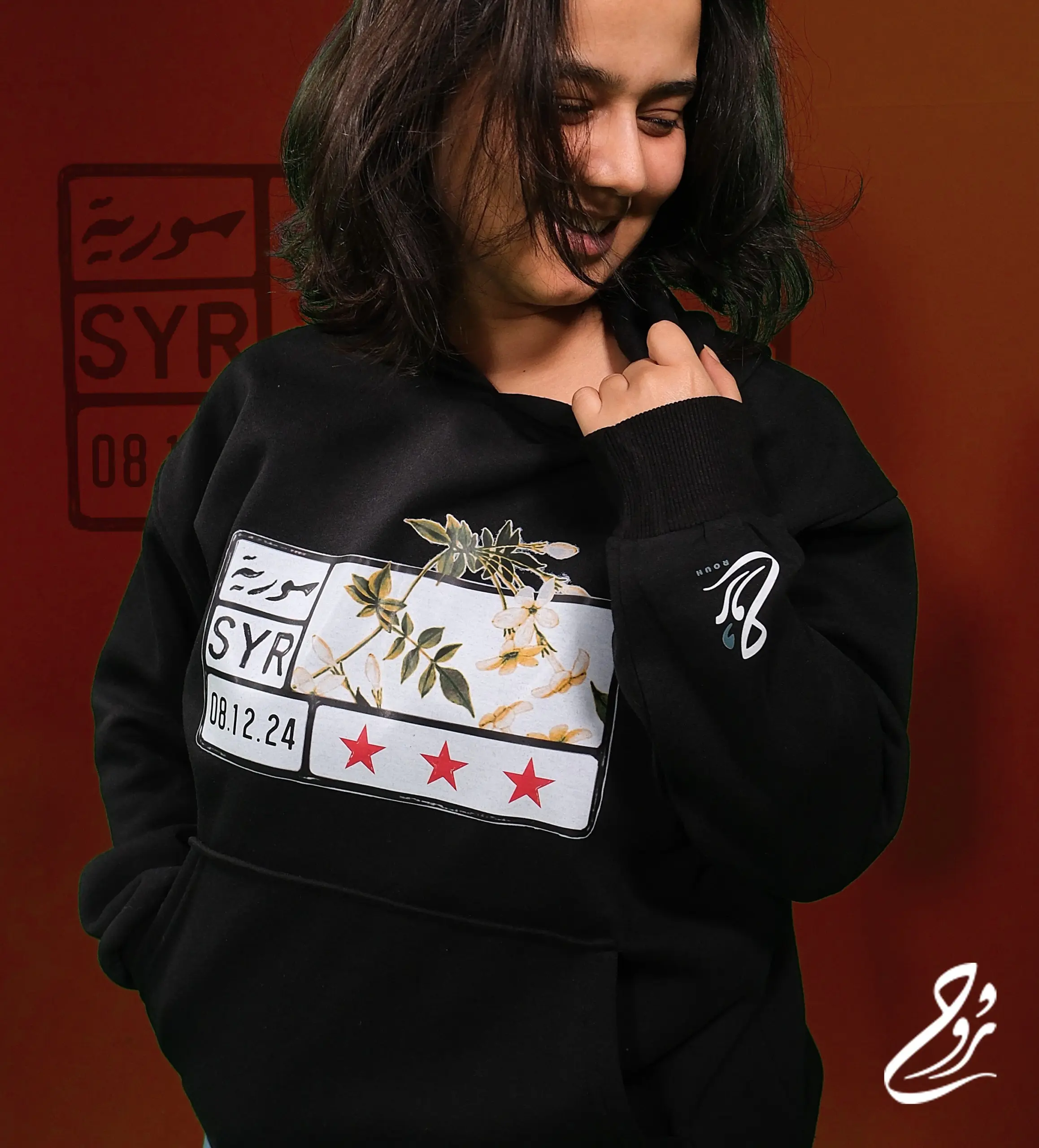 "موحًدا حب الياسمين السوري مع لوحة السيارة السورية، يتخيل هذا التصميم بأسلوب الشارع الشوارع الجديدة لسوريا مزينة بثالث نجوم الثورة."